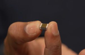 A tiny solid-state lithium microbattery held between two fingers.